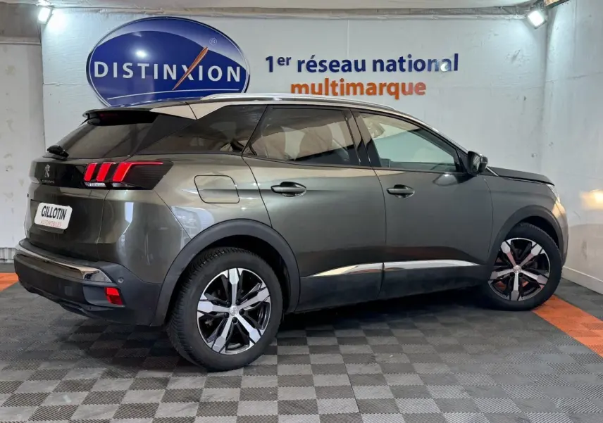 Vue 3/4 arrière droite d’un Peugeot 3008 vert métallisé avec feux arrière à LED et jantes noires et argentées.