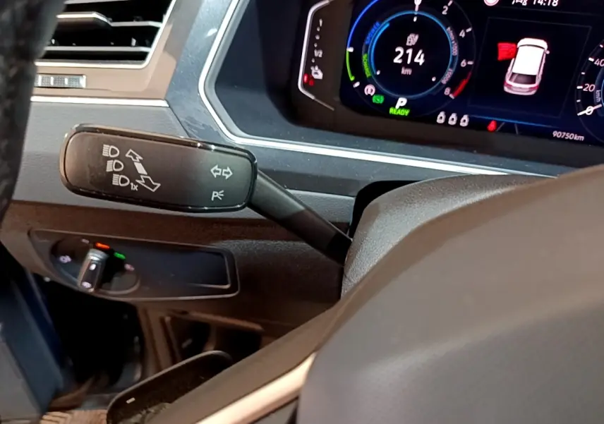 Gros plan intérieur sur le combiné d'instruments digital et la commande de clignotants du Volkswagen Tiguan bleu 1.4 eHybrid 2021.