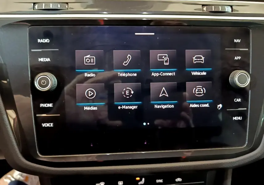 Écran tactile central du Volkswagen Tiguan 1.4 eHybrid 2021 affichant les menus radio, téléphone, navigation et véhicule.