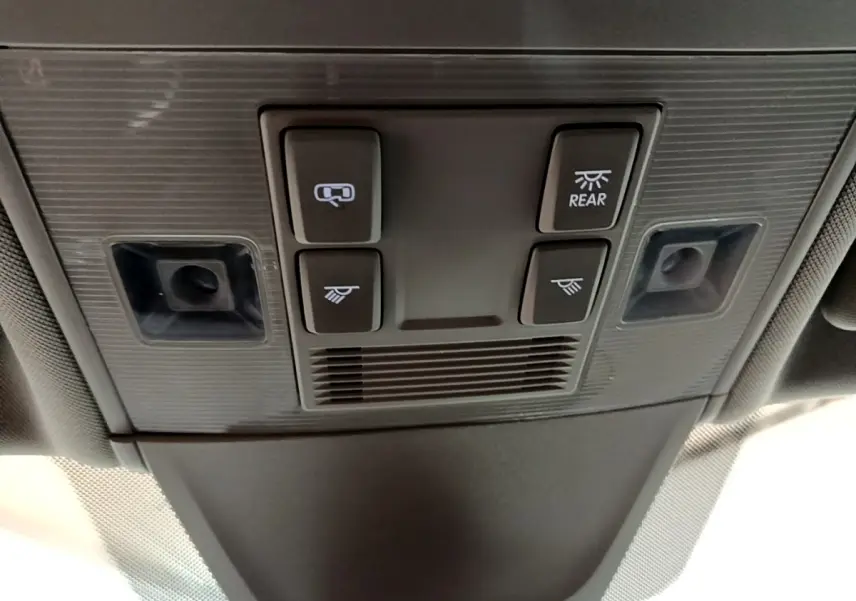 Gros plan sur la console de plafonnier avec commandes d’éclairage et capteurs dans un Volkswagen Tiguan bleu hybride rechargeable.