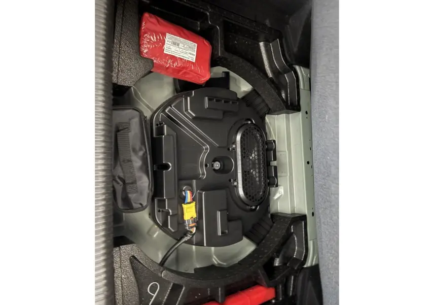 Vue rapprochée du coffre de la Peugeot 308 2024 montrant le compartiment sous plancher avec équipement de secours.