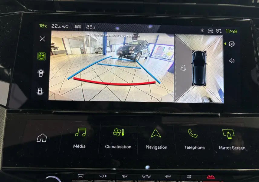Vue écran caméra de recul avec affichage 3D et image d'une voiture noire en intérieur sur dalle carrelée.
