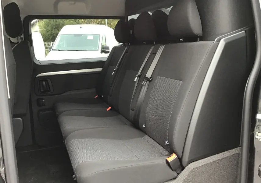Vue latérale intérieure côté droit du Peugeot Expert Cabine Approfondie gris titane, montrant la banquette arrière 5 places en tissu noir.