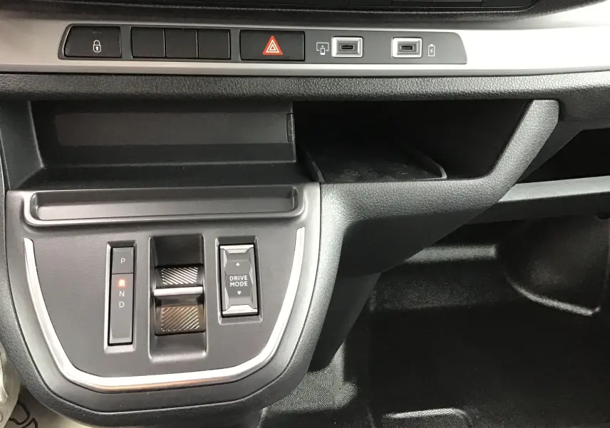 Gros plan sur la console centrale noire du Peugeot Expert XL gris titane, avec sélecteur de boîte auto et bouton Drive Mode.