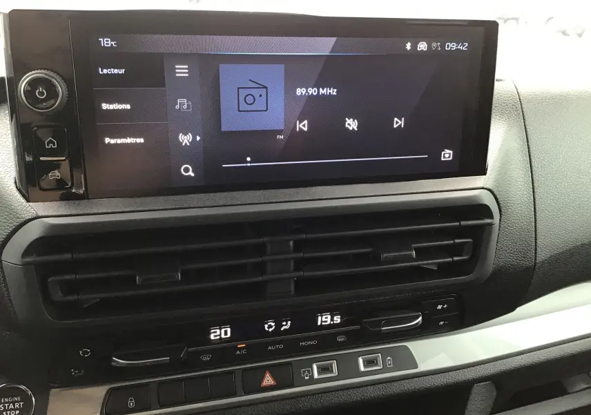 Vue rapprochée de l’écran tactile et de la console centrale du Peugeot Expert gris titane, avec commandes climatisation et démarrage sans clé.