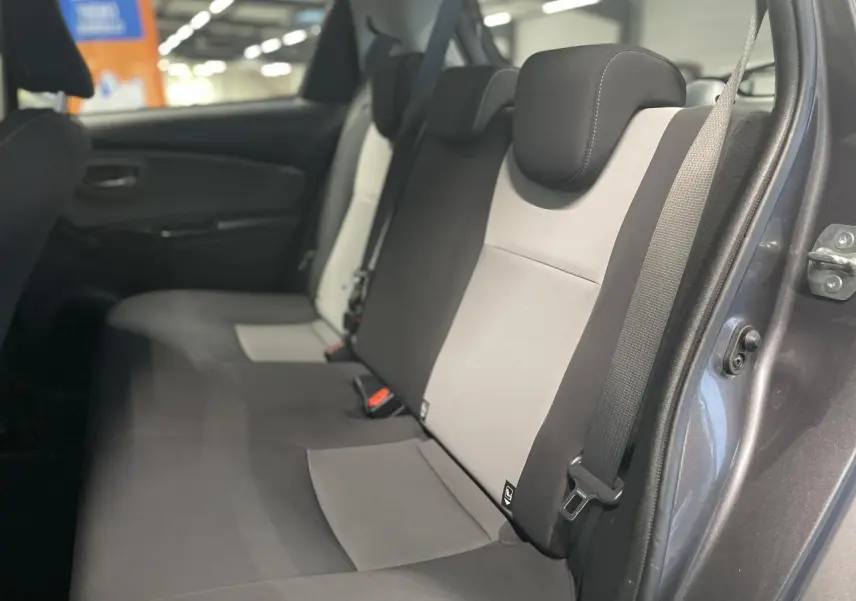 Vue intérieure côté droit sur la banquette arrière bicolore gris clair et noir d'une Toyota Yaris hybride 2020 gris foncé métallisé.