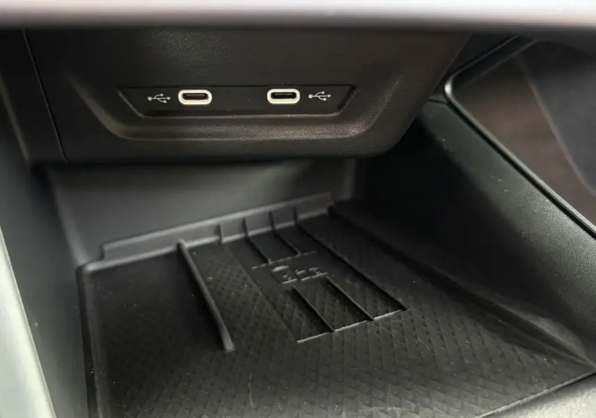 Gros plan sur la console centrale du CUPRA TERRAMAR 2024, montrant deux ports USB-C et un espace de rangement noir texturé.