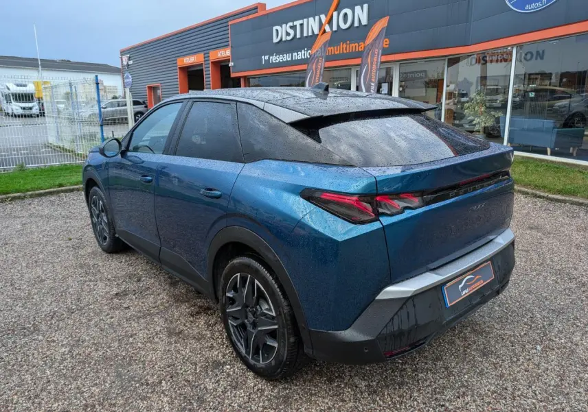 Vue 3/4 arrière droite d’un Peugeot 3008 GT hybride bleu métallisé avec toit noir et feux arrière à griffes LED.