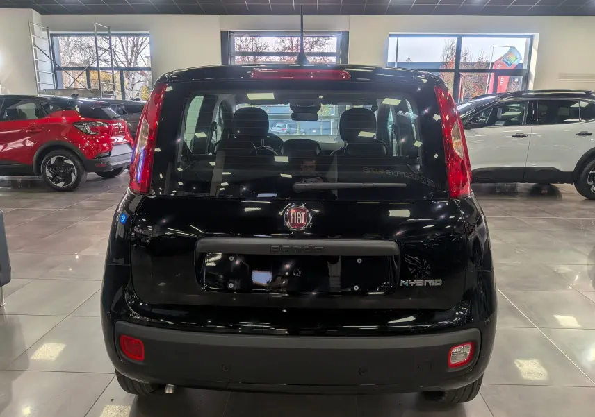 Vue arrière d'une FIAT Panda 1.0 70 CH Hybrid City noire, avec logo Fiat et badge Hybrid visibles en concession.
