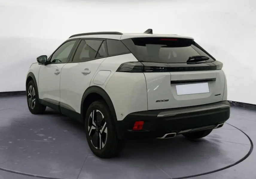 Vue 3/4 arrière gauche du Peugeot 2008 Hybrid blanc avec barres de toit et jantes alliage 17 pouces.