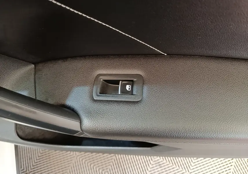 Détail de la poignée intérieure de coffre noir du Volkswagen Tiguan blanc 2023, version hybride rechargeable R-Line.