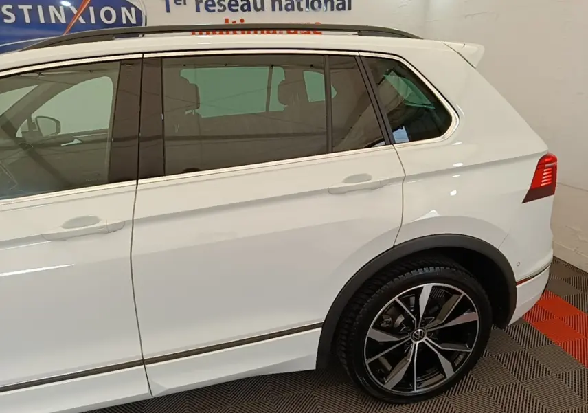 Vue latérale côté gauche d’un Volkswagen Tiguan blanc 1.4 eHybrid 245 DSG6 R-Line avec jantes noires et chrome.