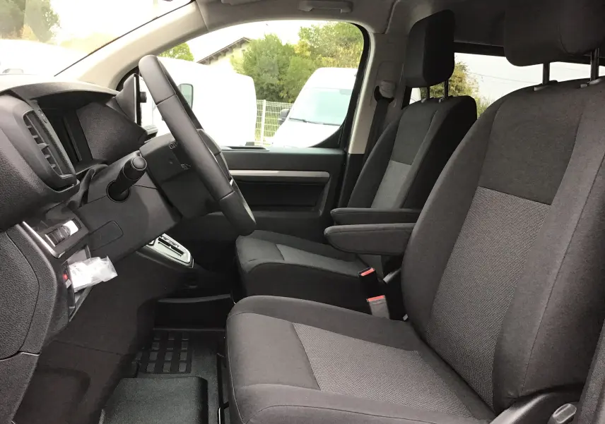 Vue intérieure côté conducteur du Peugeot Expert Cabine Approfondie gris titane, montrant les sièges avant et le volant.