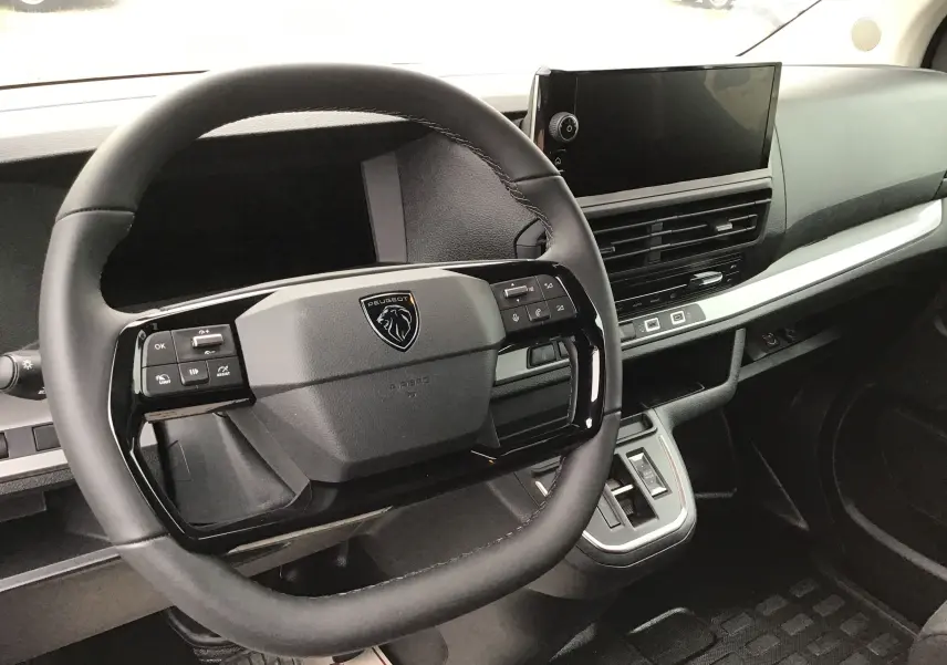 Vue intérieure centrée sur le volant Peugeot noir et le tableau de bord moderne du Expert Cabine Approfondie gris titane.