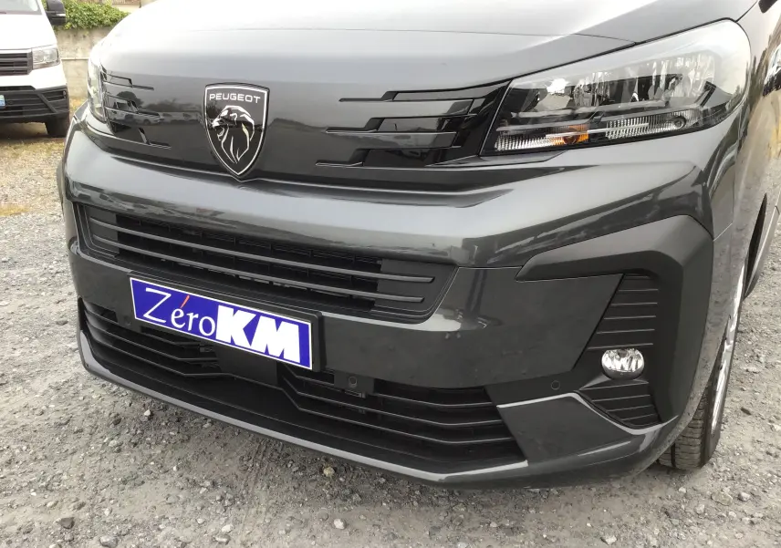 Vue avant rapprochée du Peugeot Expert Cabine Approfondie gris titane avec calandre noire et logo lion distinctif.