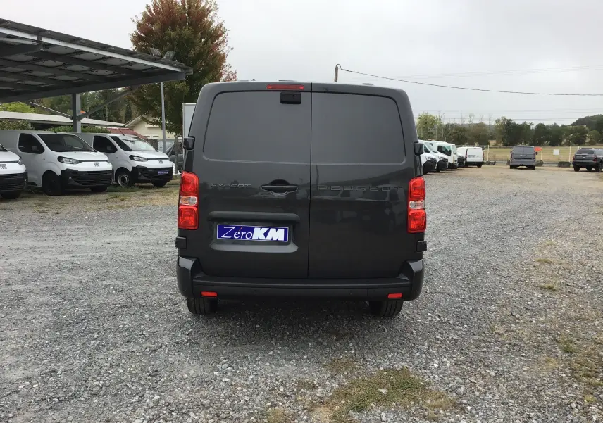 Vue arrière d’un Peugeot Expert cabine approfondie gris titane, avec portes battantes et feux arrière rouges visibles.