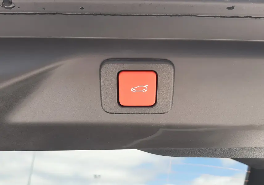 Bouton rouge de fermeture électrique du hayon sur Peugeot 3008 1.2 Hybrid 145ch GT bleu Obsession, vue intérieure du coffre.