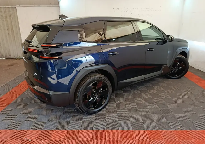 Vue 3/4 arrière droite d'un Citroën C5 hybride bleu avec jantes noires et feux arrière LED distinctifs.