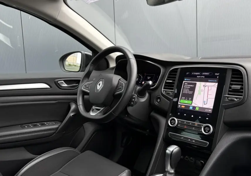 Intérieur de la Renault Mégane Break 2024, vue côté conducteur, tableau de bord noir avec écran tactile GPS EasyLink vertical.
