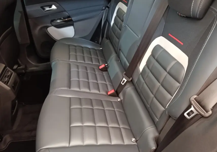 Vue intérieure côté droit des sièges arrière en cuir noir avec surpiqûres et détails blancs du Citroën C5 Hybride 2026.