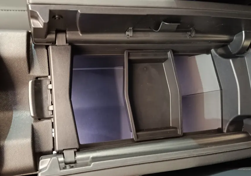 Vue rapprochée de l'intérieur du coffre à gants noir du Citroën C5 Hybride 2026, avec compartiment amovible.