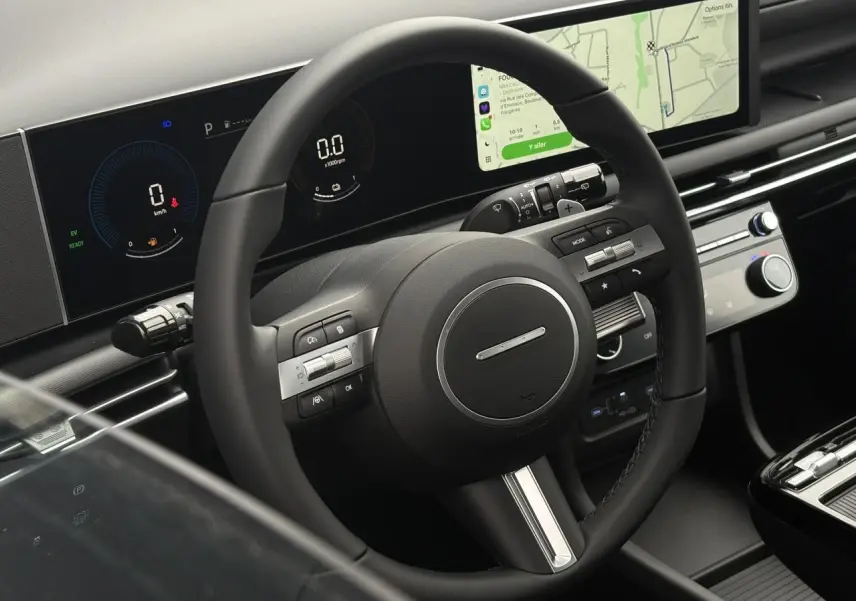 Vue intérieure du volant et du tableau de bord numérique du Hyundai Tucson 2026 avec écran tactile central et commandes au volant.