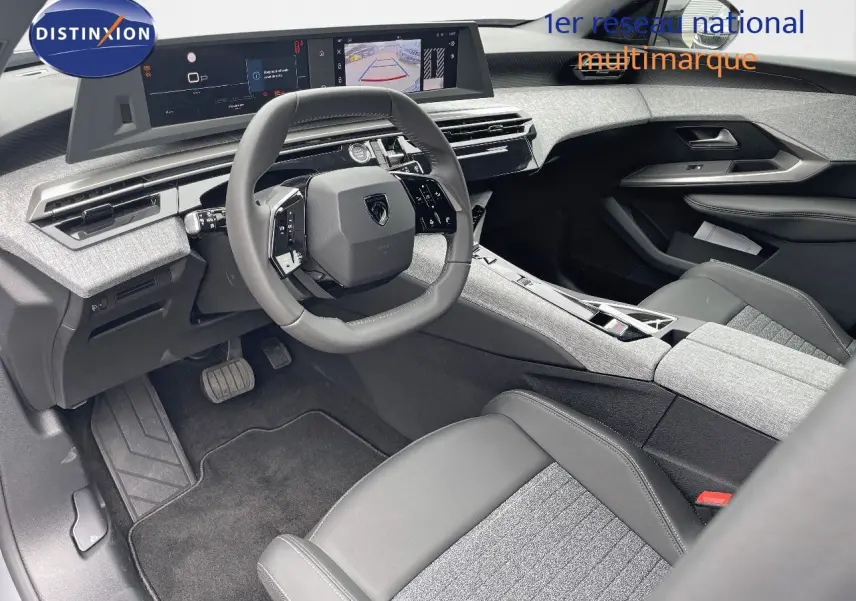 Intérieur du Peugeot 5008 Hybrid 2025 côté conducteur, volant compact et tableau de bord numérique avec finitions gris clair et cuir noir.