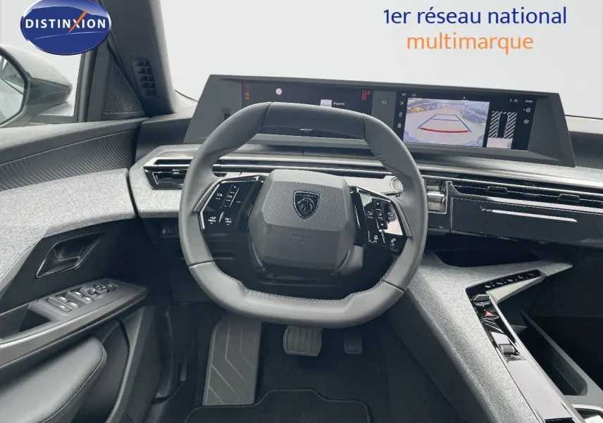 Vue intérieure du poste de conduite du Peugeot 5008 Hybrid 2025, avec volant compact et écran numérique large affichant la caméra de recul.
