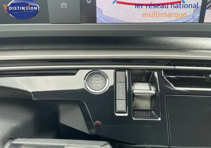 Détail de la console centrale noire brillante du Peugeot 5008 Hybrid 2025 avec bouton start/stop et commandes de boîte auto.
