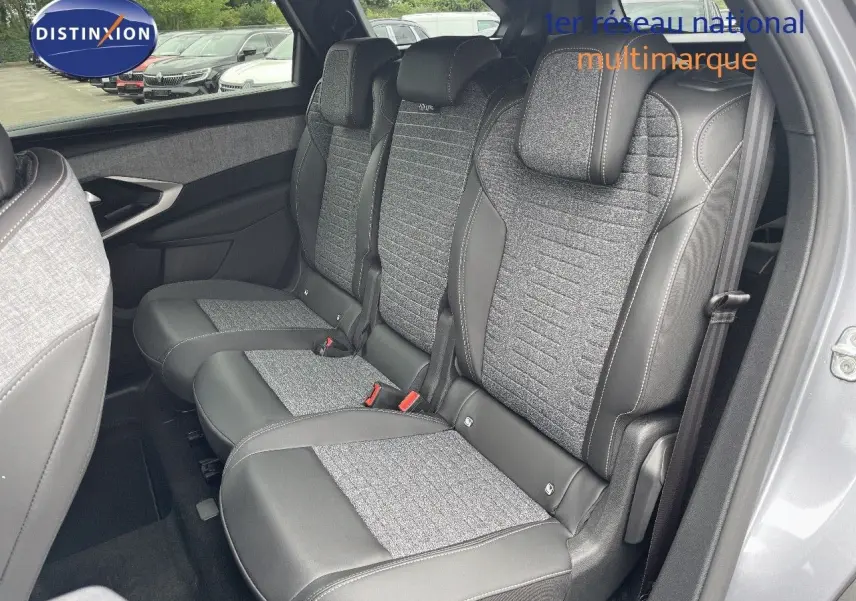 Vue intérieure sur les sièges arrière en tissu gris et cuir noir du Peugeot 5008 Hybrid 136ch 2025, porte ouverte côté droit.