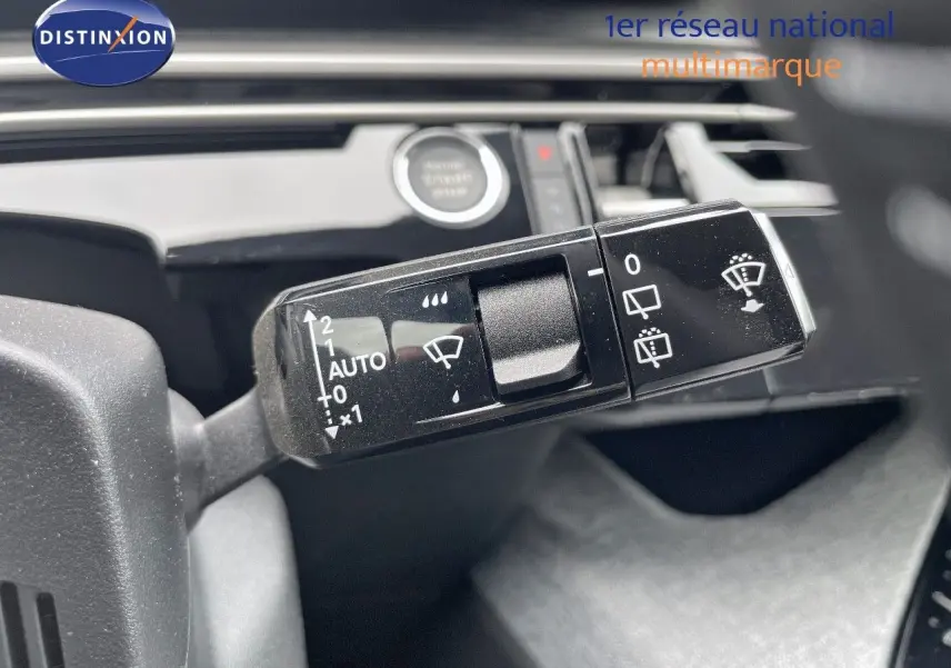 Gros plan sur la commande des essuie-glaces du Peugeot 5008 gris Artense, intérieur noir avec bouton start visible.