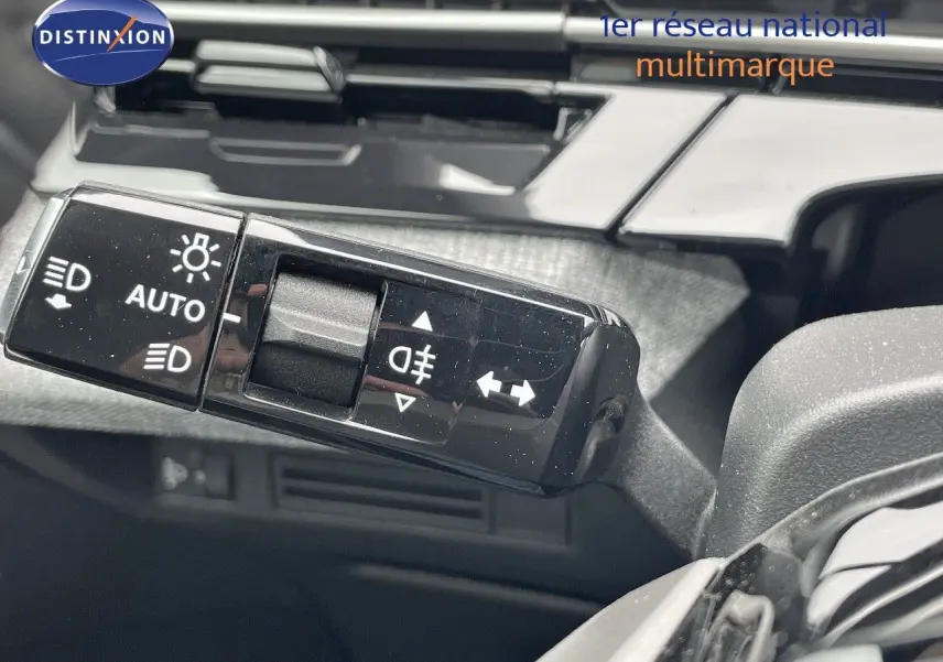 Gros plan sur la commande des feux et clignotants dans l'habitacle du Peugeot 5008 gris Artense Hybrid 2025.