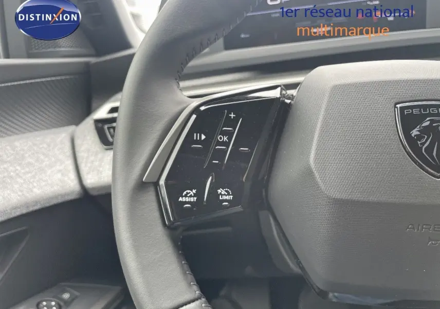 Gros plan sur le volant cuir noir du Peugeot 5008 2025 avec commandes d'assistance et limiteur visibles.