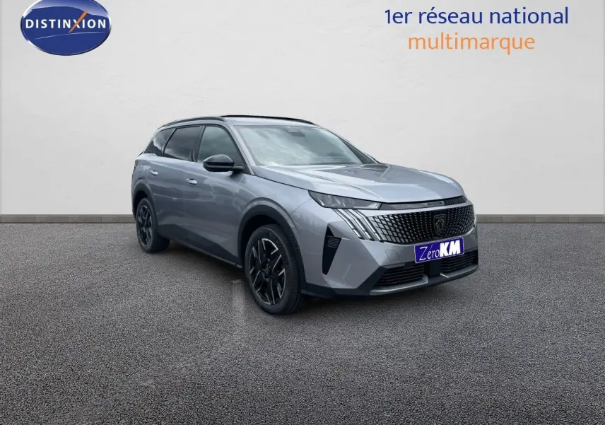 Peugeot 5008 Hybrid 136ch Allure gris Artense métal en 3/4 avant, soulignant sa calandre distinctive et ses jantes noires.