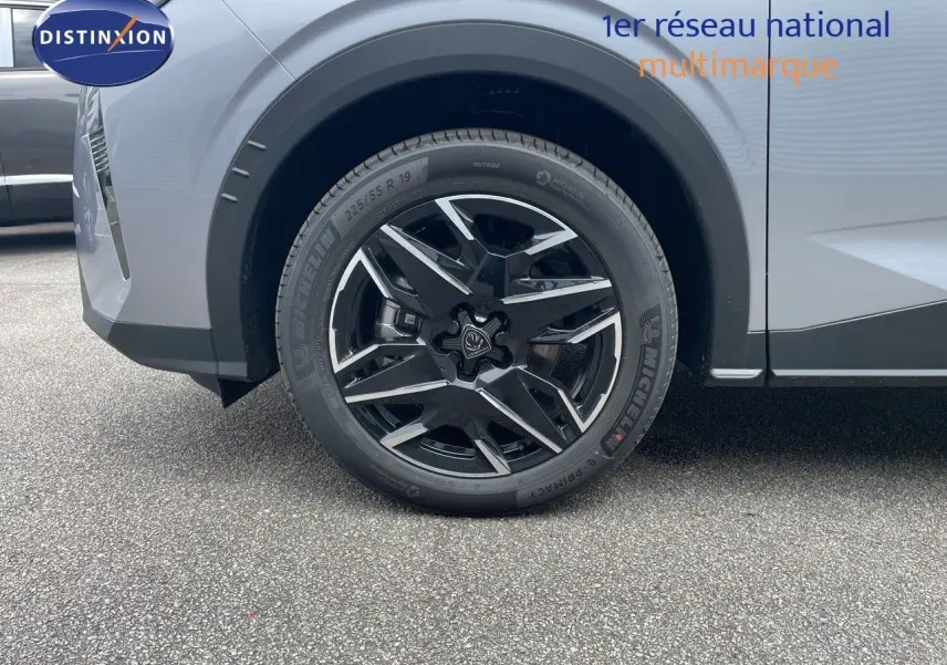 Gros plan sur la roue avant gauche du Peugeot 5008 gris Artense Métal avec jante noire et argentée design moderne.