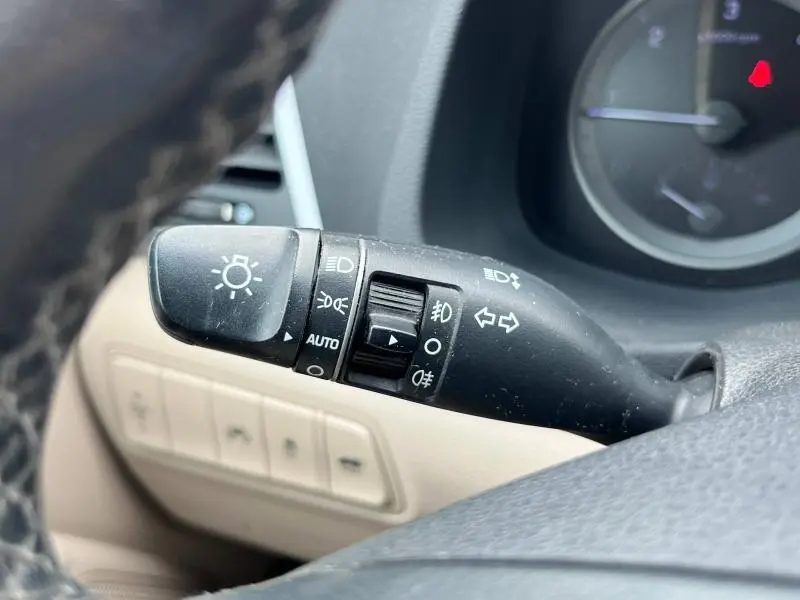 Gros plan sur la commande des phares et clignotants du Hyundai Tucson 2017, intérieur beige et noir visible.
