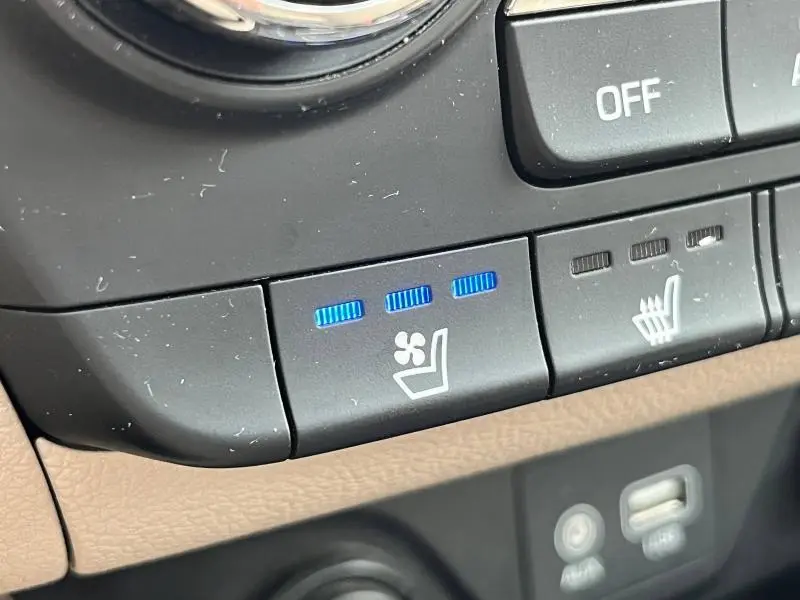Gros plan sur les commandes de ventilation et chauffage des sièges dans l'habitacle beige du Hyundai Tucson 2017.