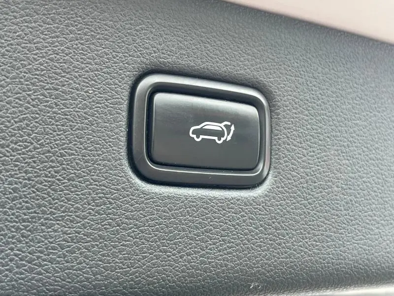 Bouton noir de commande d'ouverture du coffre sur le revêtement intérieur du Hyundai Tucson White Sand 2017.