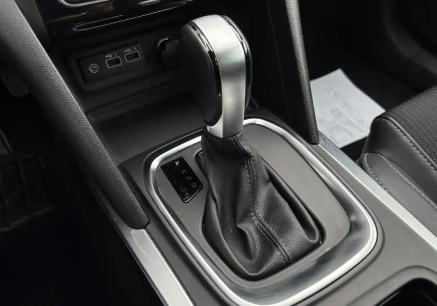 Le levier de vitesses automatique en cuir noir et métal dans la console centrale d'une Renault Mégane Break 2024.