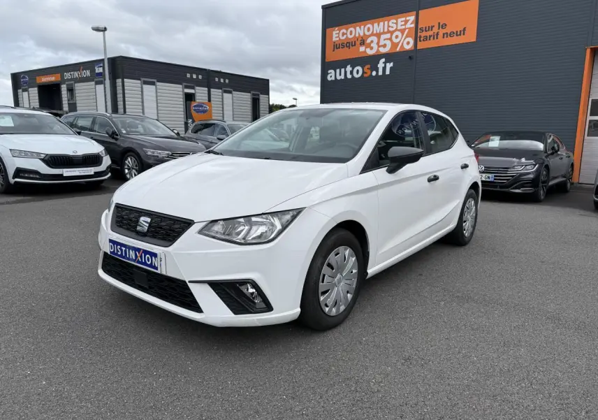 SEAT Ibiza blanc candy vue 3/4 avant droit, avec jantes enjoliveurs et rétroviseurs noirs sur parking.