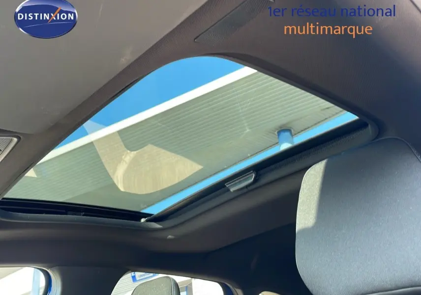 Toit panoramique ouvert vu de l'intérieur côté conducteur du Renault Captur bleu Iron Metal 2025 finition Esprit Alpine.