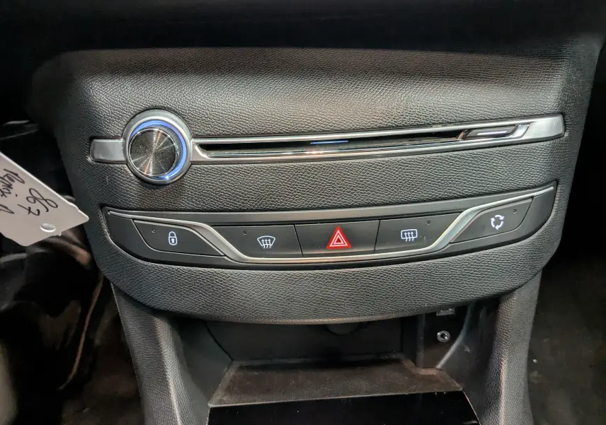 Vue rapprochée du tableau de bord noir de la Peugeot 308 1.2 PureTech 110 Style avec commandes de sécurité et ventilation.