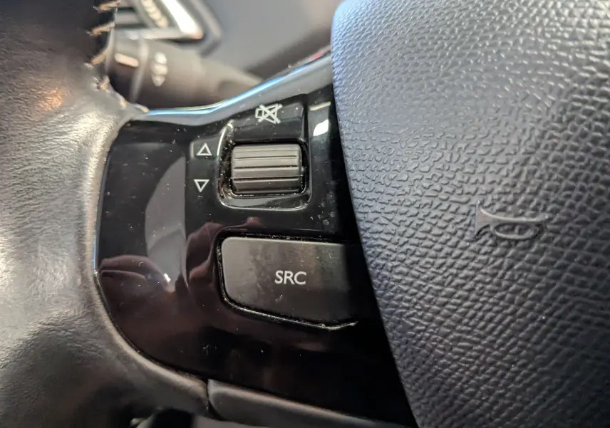 Gros plan sur les commandes gauche du volant noir de la Peugeot 308 1.2 PureTech 110 Style de 2017.