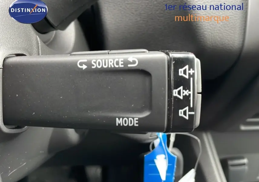 Gros plan sur la commande au volant du Renault Captur 2025 noir étoile métal, avec boutons source et mode visibles.