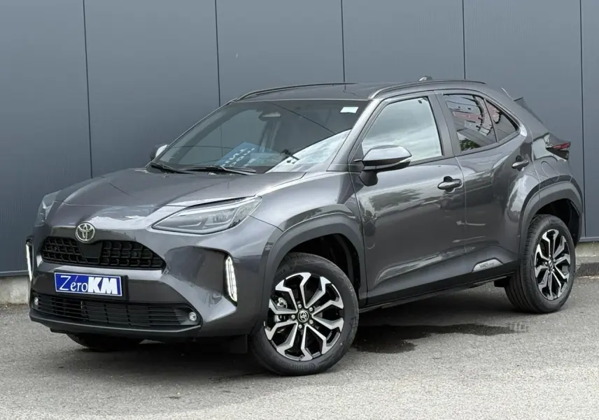 Toyota Yaris Cross gris Atlas vue 3/4 avant droit, avec jantes alliage noires et détails LED verticaux.