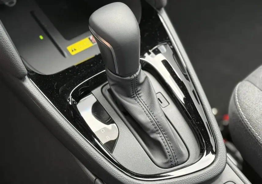 Gros plan sur le levier de vitesses automatique noir de la Toyota Yaris Cross 1.5 Hybrid 2026, intérieur gris.
