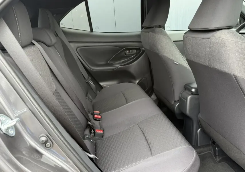 Vue côté gauche des sièges arrière gris foncé du Toyota Yaris Cross 1.5 Hybrid 2026 avec ceinture de sécurité visible.