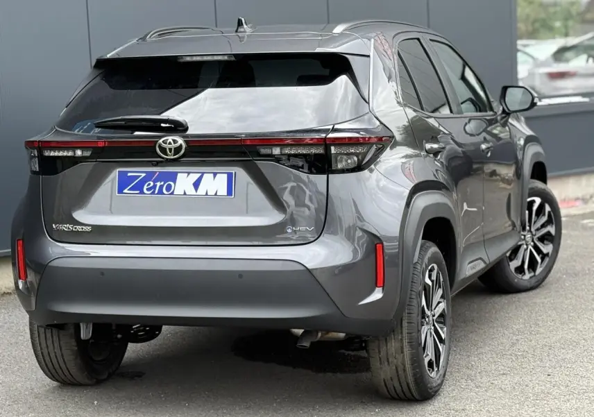 Vue 3/4 arrière droite d'une Toyota Yaris Cross 1.5 Hybrid 116 Design gris Atlas avec feux arrière LED et jantes alliage.