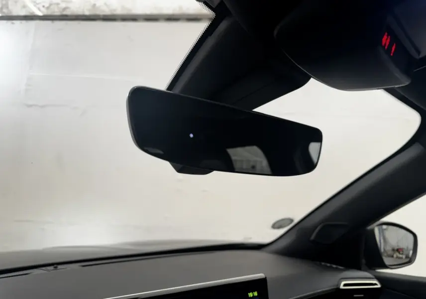 Vue intérieure du tableau de bord et rétroviseur noir du Peugeot E-2008 électrique GT Pack 2021, côté droit.