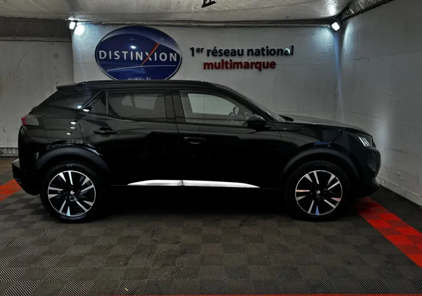 Peugeot E-2008 électrique GT Pack noir vue de profil côté gauche, jantes alliage distinctives, intérieur visible.